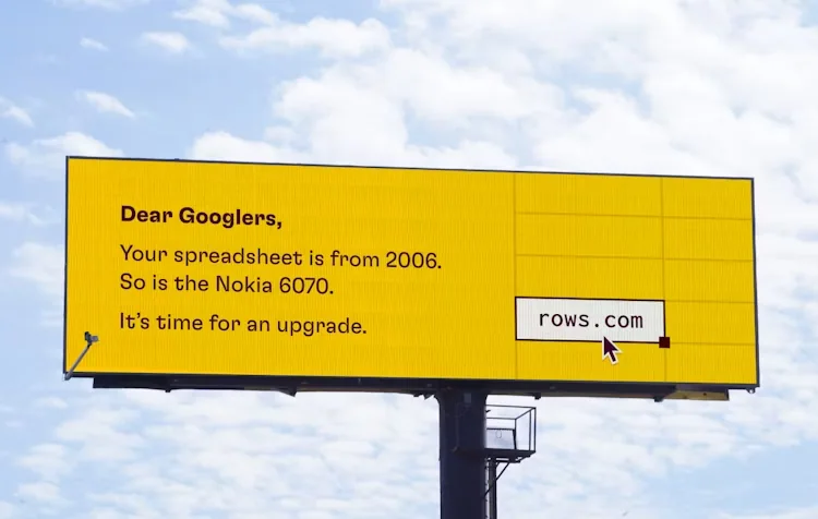Yellow Rows billboard addressing Googlers, comparing an older spreadsheet to a Nokia 6070 and suggesting an upgrade.